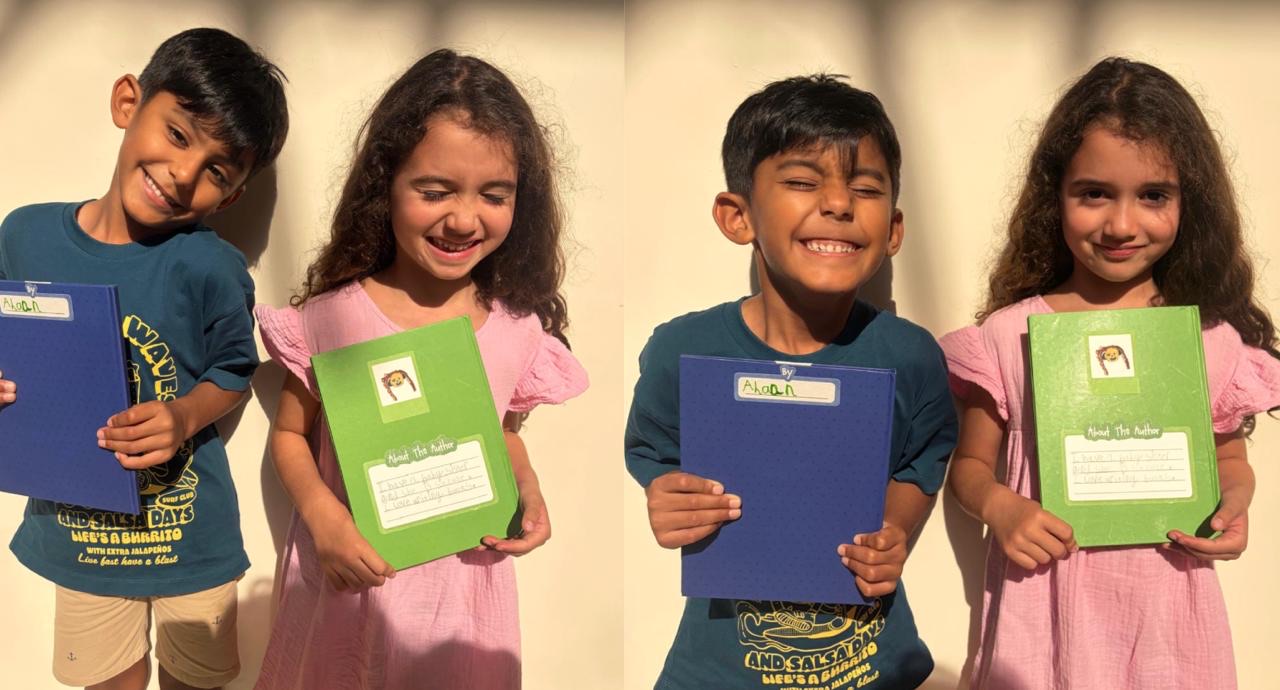 Two young Page Zero authors proudly holding their finished, printed books